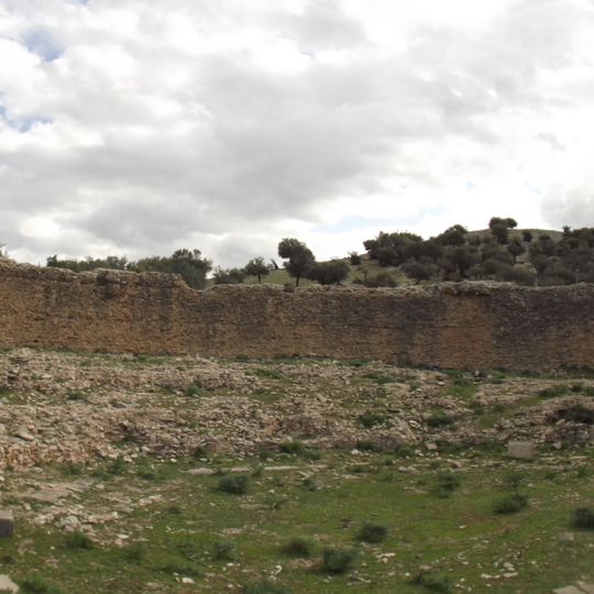 Édifice demi-circulaire dont il subsiste un mur extérieur assez élevé ainsi que le soubassement d'un édifice rectangulaire