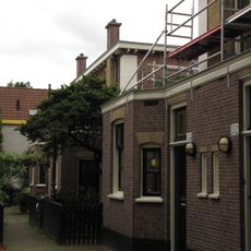 Blok van vier rug-aan-rug gebouwde woningen op vierkante plattegrond, bestaande uit begane grond en verdieping onder een plat dak