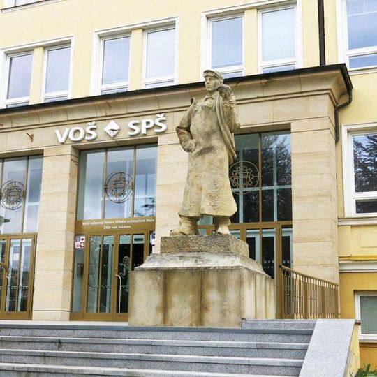 Socha svářeče vpravo před průmyslovou školou v Studentské ulici v Žďáru nad Sázavou