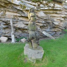 Dřevěné plastiky pod skalou v amfitátru v Lipnici nad Sázavou