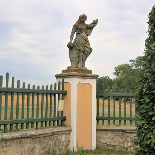 Alegorická socha Srpen v ohradě zámecké zahrady ve Veltrusech