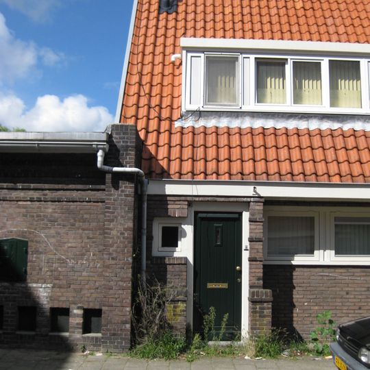 Blok met 8 keukenwoningen, zo genoemd vanwege destijds nieuwe plaatsing van keuken aan de voorzijde, aan de zijkant een houten topgevel, bouwstijl Amsterdamse School.