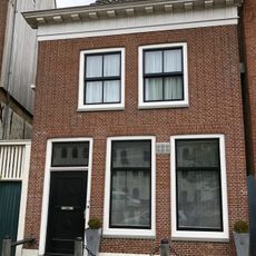 Vrij laag pand met rechte kroonlijst met metopen-trigliefen-fries onder zadeldak