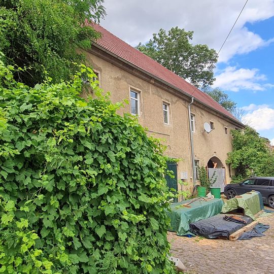 Wohnstallhaus und daran angebautes Stallgebäude, weiteres Wohnhaus und daran angebautes Seitengebäude sowie Scheune eines Dreiseithofes, mit Toreinfahrt und Begrenzungsmauer an der Hofzufahrt Mauna 1; 1b