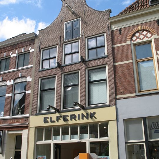 Huis met winkelpui in gewijzigde klokgevel bekroond door houten geprofileerd lijstje