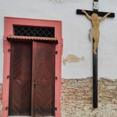 Kříž na zdi kostela ve Skočicích