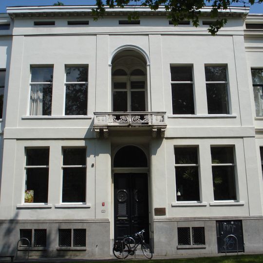 Herenhuis, met gepleisterde lijstgevel waarvan de middenpartij op de verdieping een getoogde loggia met balkon op consoles heeft