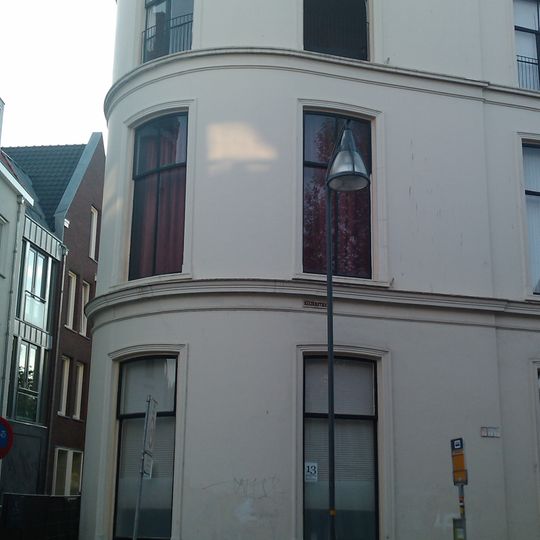 Pand, dat de afrondende linkerhoek vormt van een in het derde kwart van de 19e eeuw als een symmetrisch geheel ontworpen straatwand