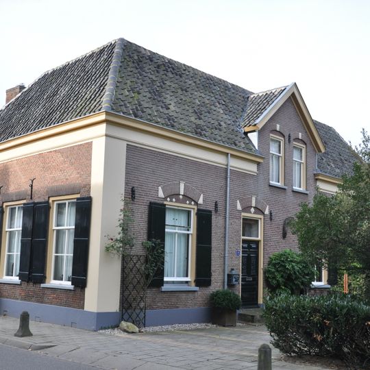 Eenvoudige boerderij met muurankers en luiken voor de vensters