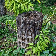 Tocón de eucalipto tallado a modo de escultura simulando un edificio o ciudad medieval abigarrada.
