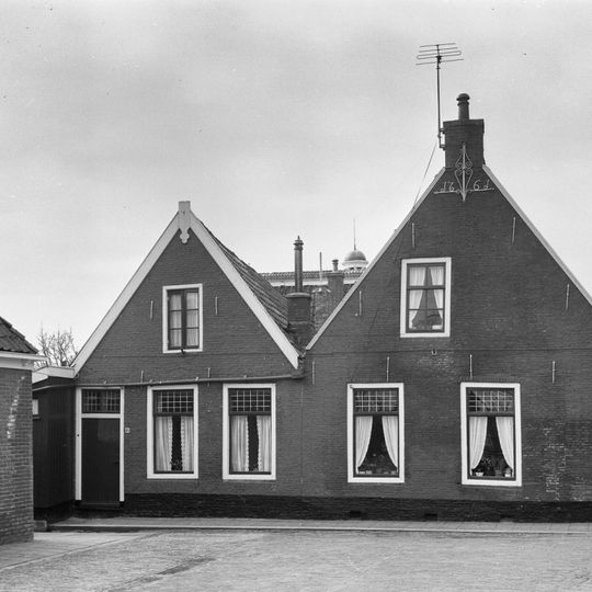 Twee panden onder zadeldak tegen puntgevel, waarvan Nije Buorren 12 met vlechtingen en aanzetlijstje