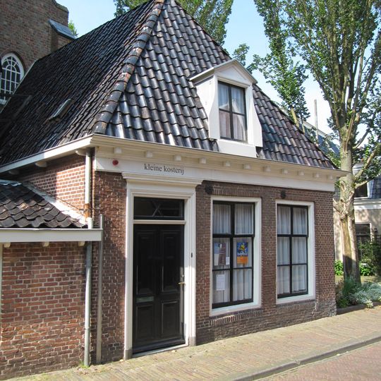 Woning onder hoog zadeldak in hoek koor en noordbeuk Jacobijnerkerk