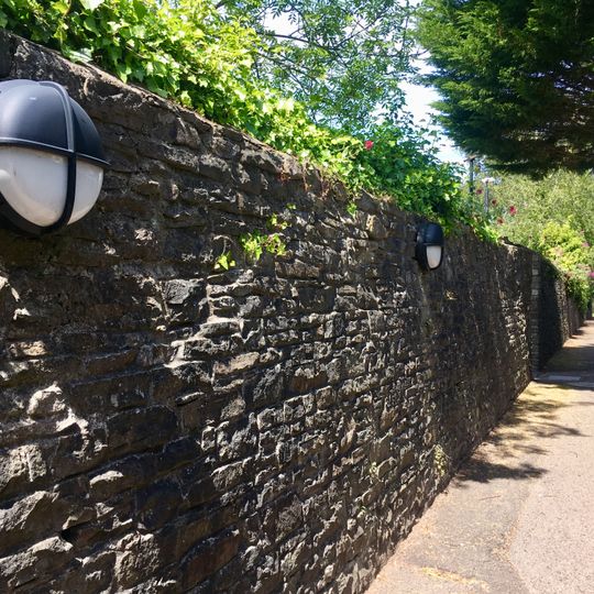 East Boundary Wall of The Lodge and car park at rear