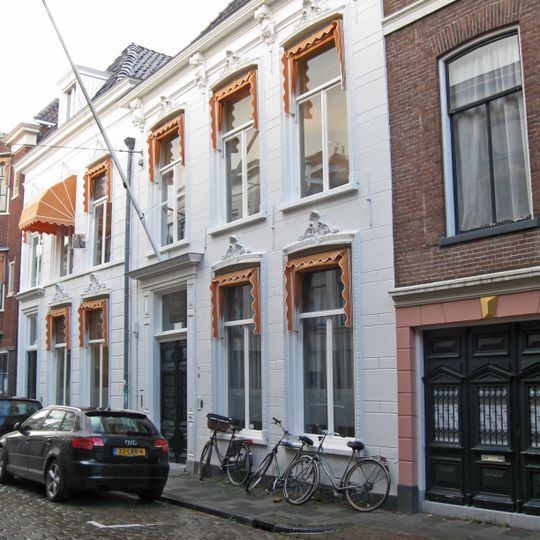 Wit gepleisterd pand met omlijste vensters