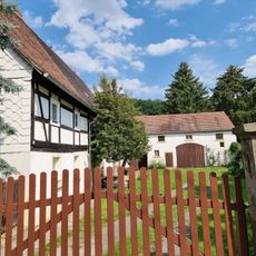 Wohnstallhaus, Scheune und zwei Sandsteinpfeiler (Hofeinfahrt) eines Bauernhofes Lindenstraße 6