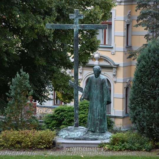 Socha světce s křížem u kostela svatých Petra a Pavla v Karlových Varech