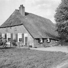 Goed bewaarde boerderij in gave landschappelijke omgeving. Strodak, vensters met luiken en negenruitsschuiframen in de voorgevel