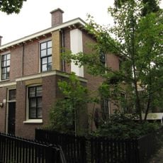 Blok van vier rug-aan-rug gebouwde woningen op vierkante plattegrond, bestaande uit begane grond en verdieping onder een plat dak