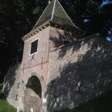 Boerenboom, sluishuis met keermuren in de omwalling