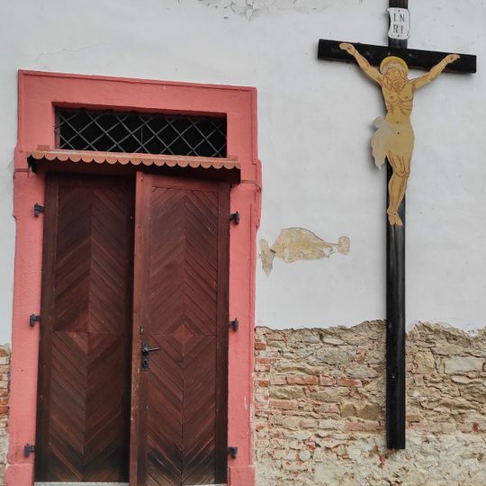 Kříž na zdi kostela ve Skočicích