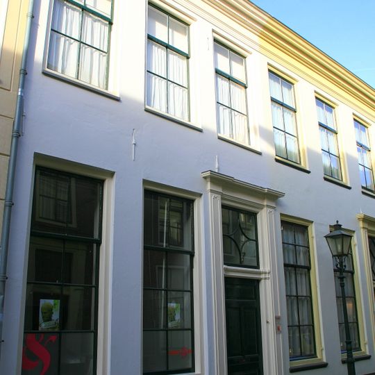 Pand met gepleisterde gevel, rechte lijst en voordeur en bovenlicht in pilasteromlijsting