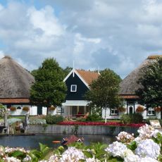Mooi vrij gelegen ten oosten van de Schilderweg in geboomte. Woonhuis in de stolp gebouwd, tweede stolp als schuur