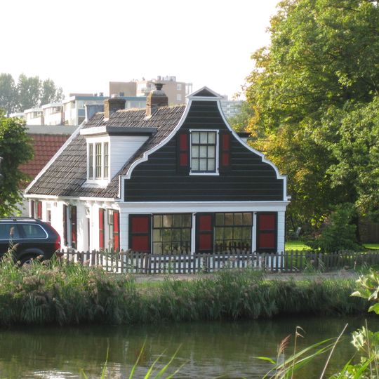 Houten molenaarshuis met klokgevel uit 19de eeuw, ernaast molen d' Armiraal
