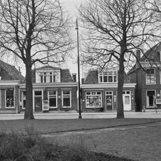 Pand met omlijste ingang, verdieping met zesruitsvensters en forse kroonlijst onder schilddak