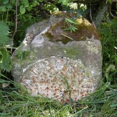 Milestone, northern end of village, just E of 90 degree bend, by entrance to some farm buildings