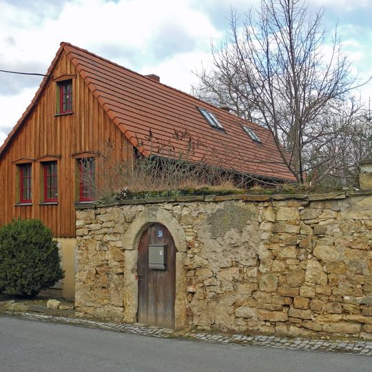 Wohnstallhaus eines Bauernhofes, dazu Hofmauer mit Toreinfahrt und Pforte Hauptstraße 20