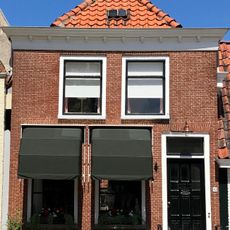 Pand met verhoogde gevel met rechte kroonlijst en schoorsteen boven voorste dakschild