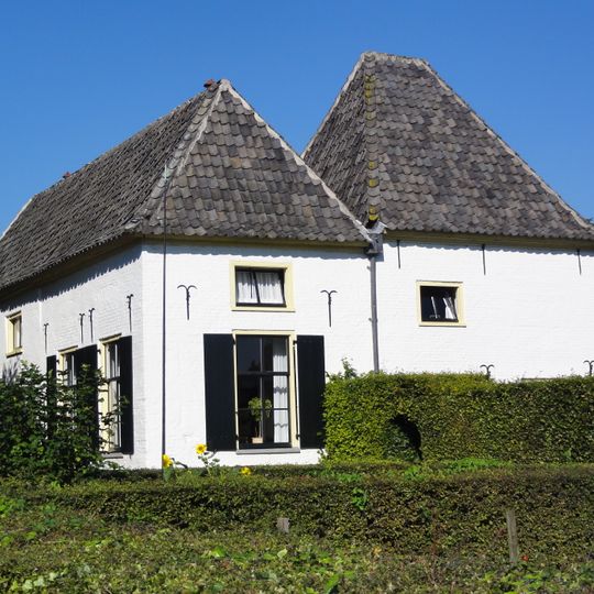 Gepleisterde boerderij met lage verdieping en pannen schilddak