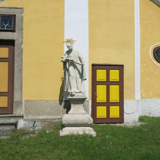 Socha světce vpravo u jižního portálu kostela Nanebevzetí v Chlumu u Třeboně