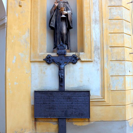 Kříž při severozápadní straně kostela Panny Marie Vítězné na Bílé Hoře