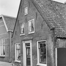 Pand met topgevel, houten deuromlijsting, getande lijst