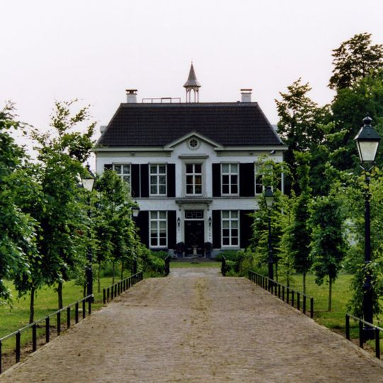 Landhuis met hoog leiendak, fronton op de middentravee, dakruiter, geblokt grijsgepleisterde gevel