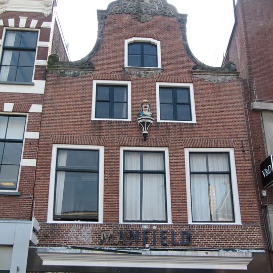 Pand met in de top rijk versierde klokgevel