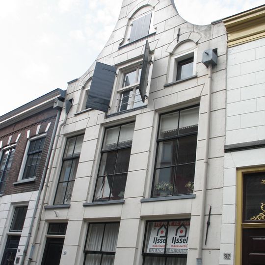 Pand met gepleisterde gevel met ingezwenkte zijkanten en hijsluiken in de middenas van de zolderverdiepingen