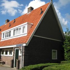 Blok met 4 keukenwoningen, zo genoemd vanwege destijds nieuwe plaatsing van keuken aan de voorzijde, aan de zijkant een houten topgevel, bouwstijl Amsterdamse School.