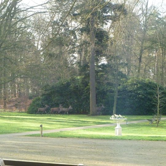 Tuinsieraad in de vorm van een kunststenen piedestal waarop een gietijzeren vaas of schaal. De piedestal heeft in iedere zijde een verdiept paneel.