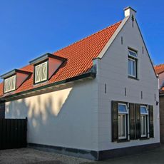 Pand met gepleisterde puntgevel, waarin topsieranker