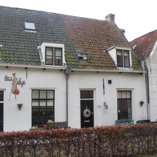 Laag huisje onder zadeldak tussen puntgevels