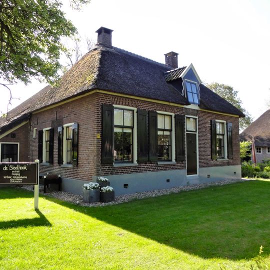 Boerderij onder rieten dak met dwars gebouwd woondeel en bedrijfsdeel met houten wanden