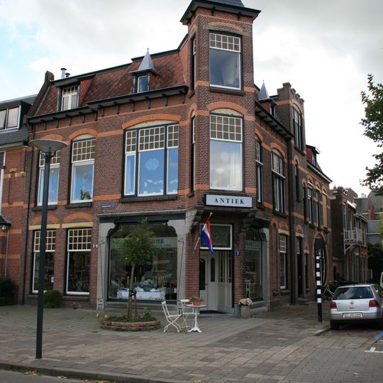 Hoekpand van oorspronkelijk twee winkels met bovenwoningen in Overgangsstijl