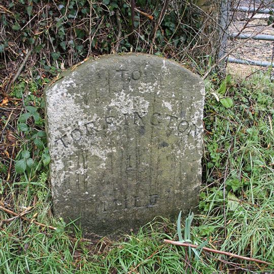 Milestone, just W of drive to Oak Park Farm, 400m E of Taddiport