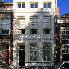 Pand met gepleisterde lijstgevel met stucdecoraties en consoles onder de kroonlijst