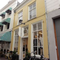 Huis met lijstgevel met versierde ingangspartij met gesneden bovenlicht en deur