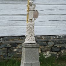 Umělecký kříž před roubenou venkovskou usedlostí čp.20 v Eši