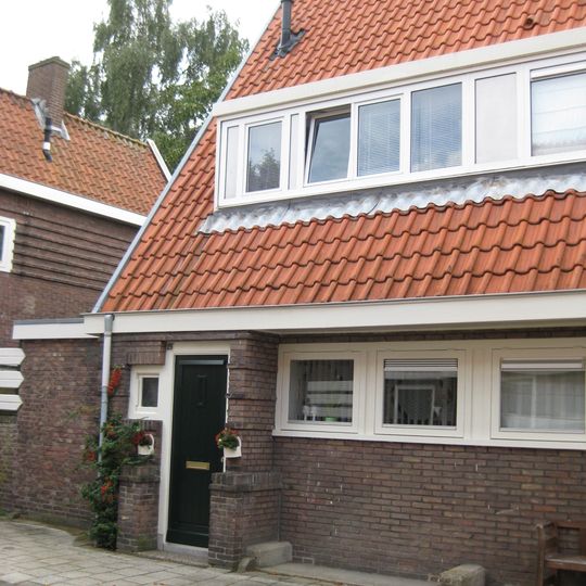 Blok met 8 keukenwoningen, zo genoemd vanwege destijds nieuwe plaatsing van keuken aan de voorzijde, aan de zijkant een houten topgevel, bouwstijl Amsterdamse School.
