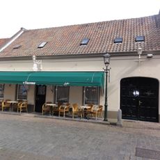 Wit dorpshuis met dwars zadeldak van rode pannen